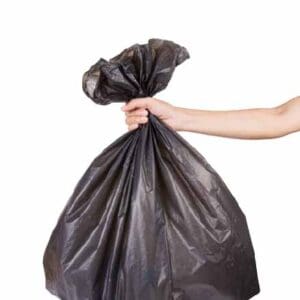 Hand holding black bag of rubbish at Dev Foods, Melbourne - Specialised Food Packaging & Cleaning Products Distributor