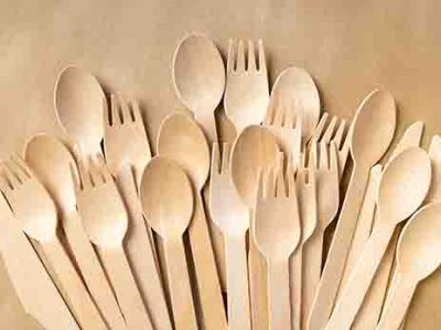 Disposable Wooden Cutlery Set on a paper background. Wooden forks, spoons and knives close-up. Wooden biodegradable table setting - Dev Foods, Melbourne - Specialised Food Packaging & Cleaning Products Distributor